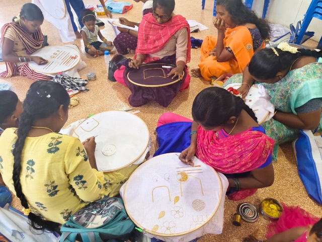 Women working on embroidery hoops